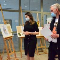 Agata Puchalska – dyrektor Biura Kultury Urzędu Marszałkowskiego i rysownik Tomasz Brański oglądają wystawę „Nora Ney i kino w przedwojennym Białymstoku”.
