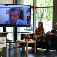 Obrady konferencyjne przez monitorem telewizyjnym.