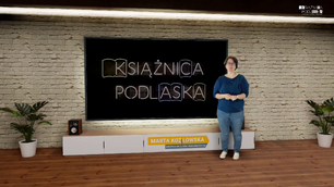 Kobieta stoi w wirtualnym studiu telewizyjnym przed dużym ekranem. Ekran wyświetla logo/napis neonowy KSIĄŻNICA PODLASKA. Kobieta ma na sobie ciemnoniebieską bluzkę i jasne dżinsy. Stoi po prawej stronie ekranu, trzymając złożone ręce przed sobą. Pod ekranem znajduje się szafka RTV z głośnikami po bokach, a na niej widoczna jest plakietka z napisem MARTA KOZŁOWSKA i pod spodem mniejszymi literami WYPOŻYCZALNIA GŁÓWNA I MIĘDZYBIBLIOTECZNA. Ściana za ekranem wygląda jak ściana z czerwonej cegły. Po obu stronach mebla RTV i ekranu znajdują się doniczkowe rośliny. U góry po prawej stronie widać logo z napisem KSIĄŻNICA PODLASKA. Podłoga jest drewniana.